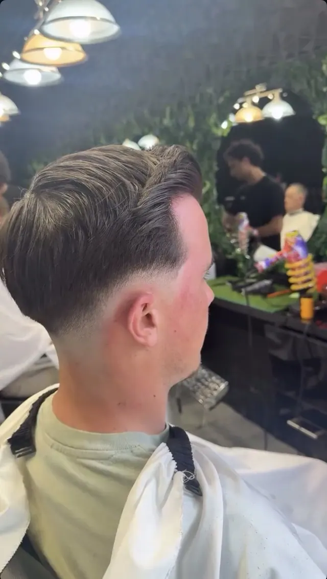 A slicked-back cut with a low fade