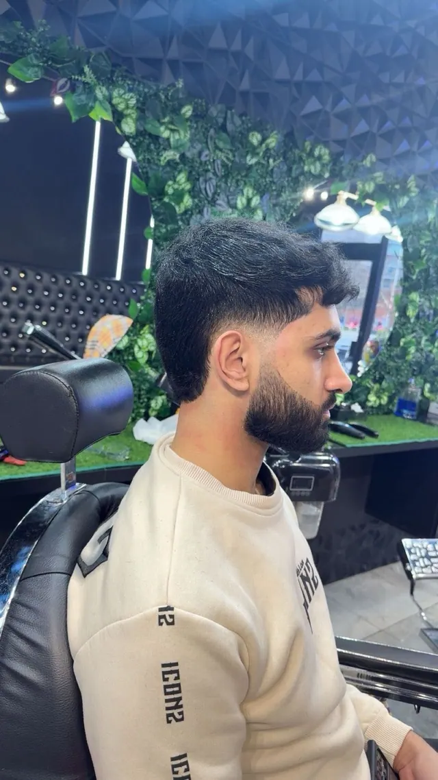 A textured fringe with a fade and a full beard