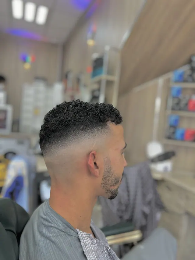 Short curls with a skin fade and a beard line